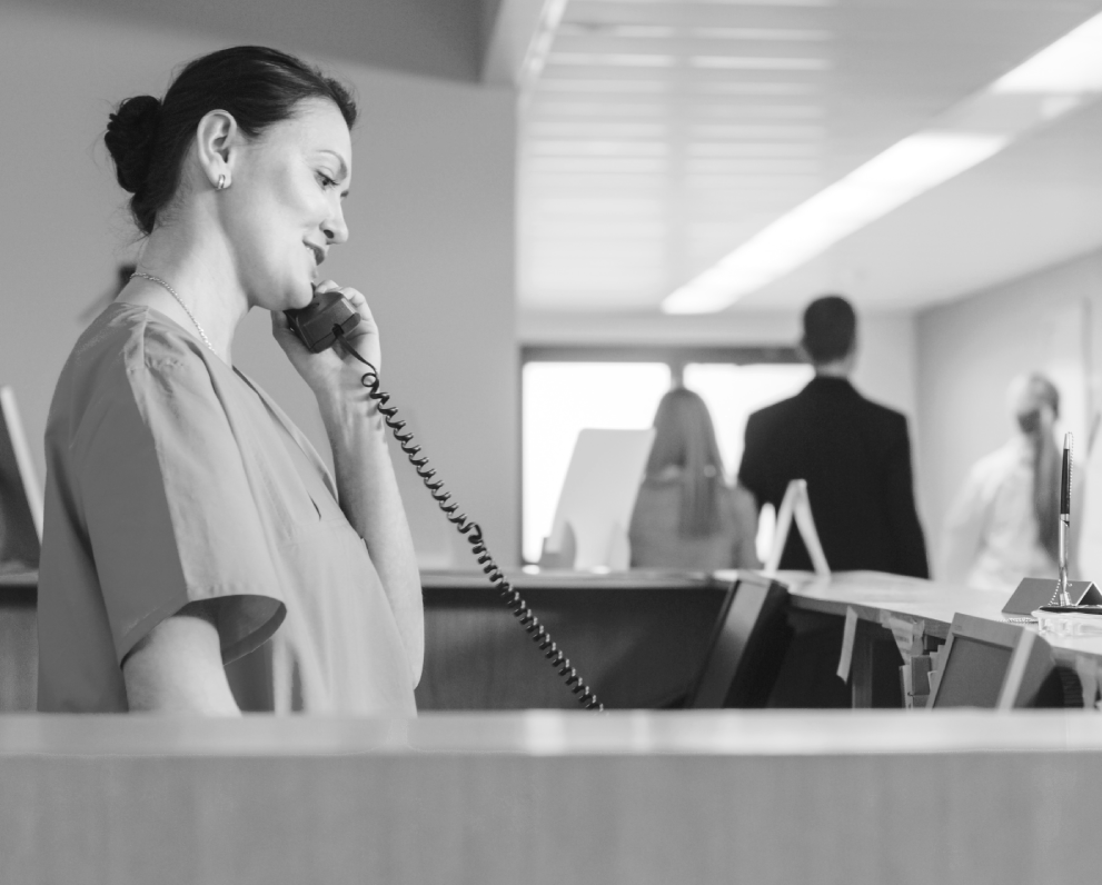 "Woman on phone at hospital front desk | OBHG"